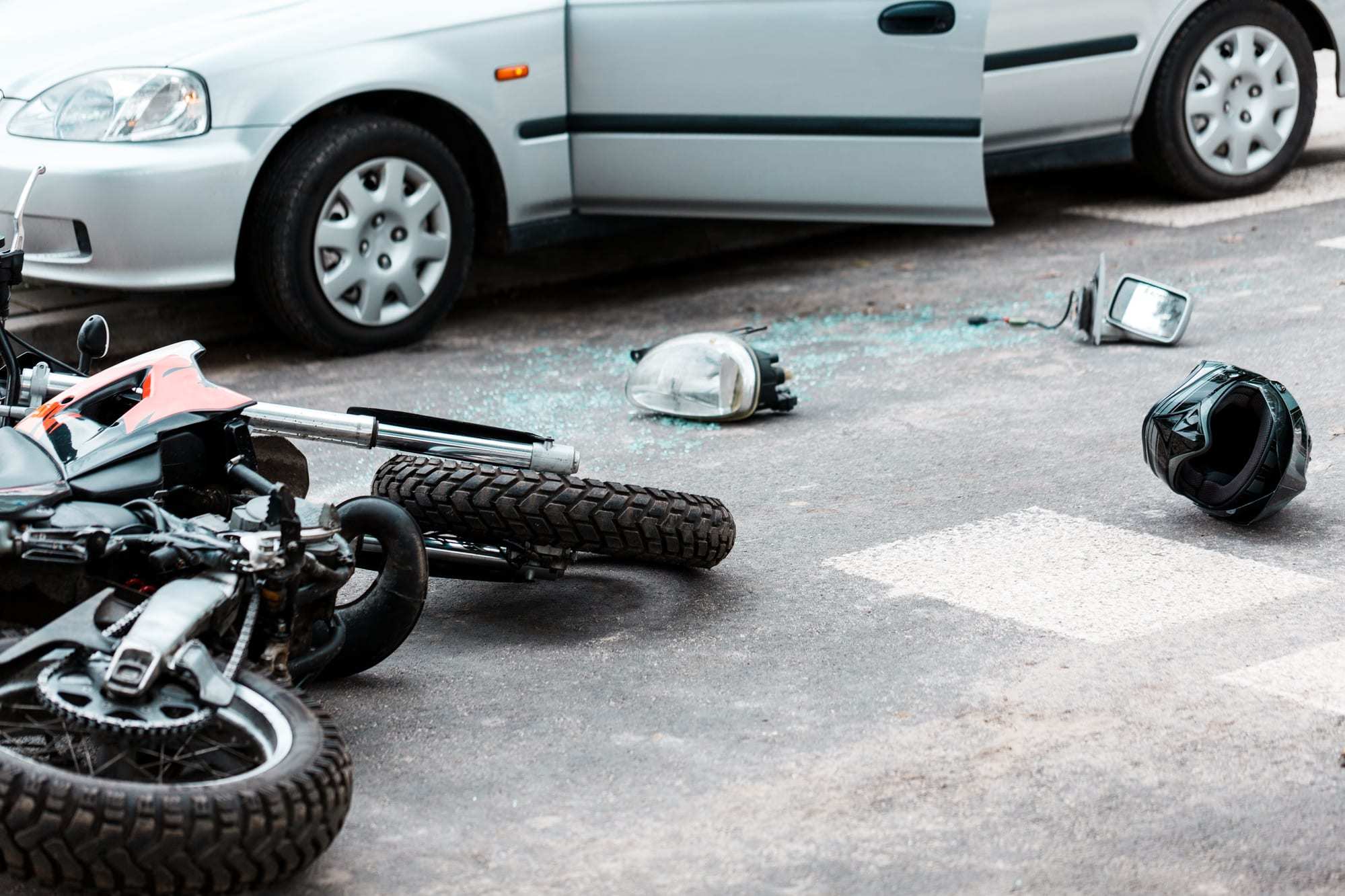 Aftermath-of-collision-with-car-and-motorcycle-bike-and-helmet-on-ground-broken-lights