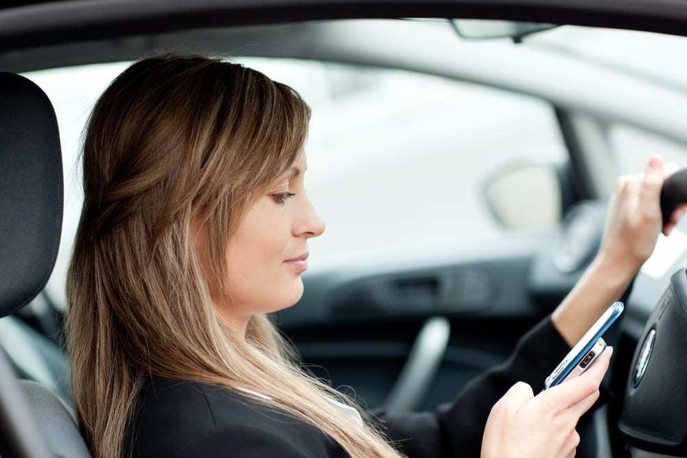 Woman sending a text while driving