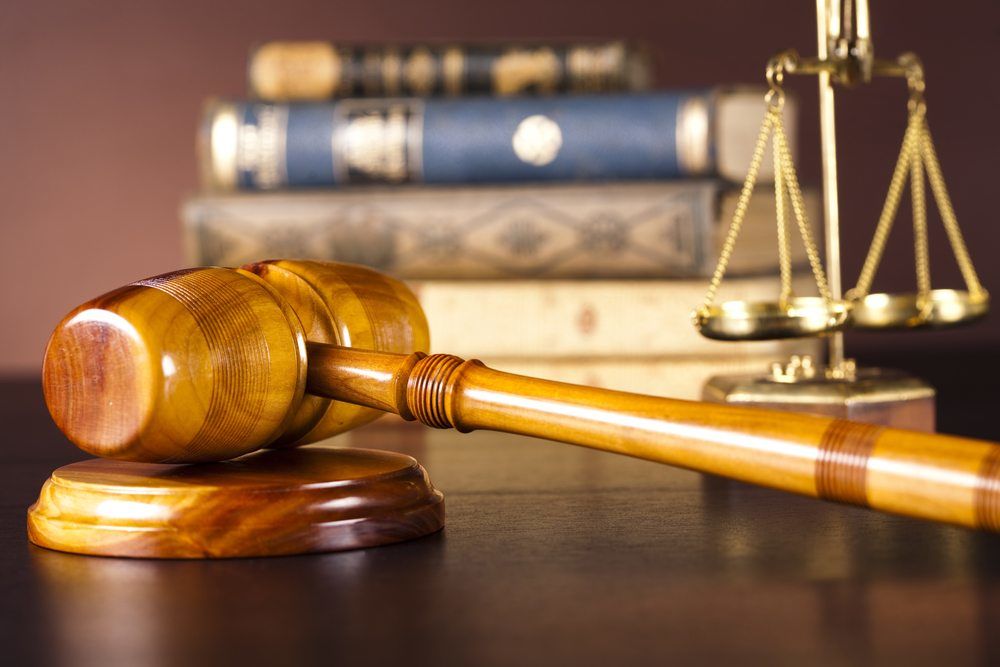 gavel on table in front of law scales and books