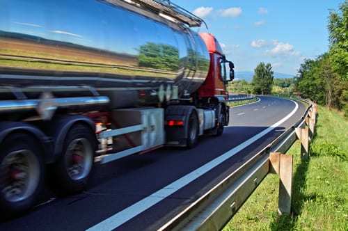 Mirroring the landscape chrome tank truck moving on a highway