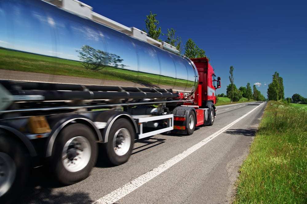 Mirroring the landscape chrome tank truck moving on a highway