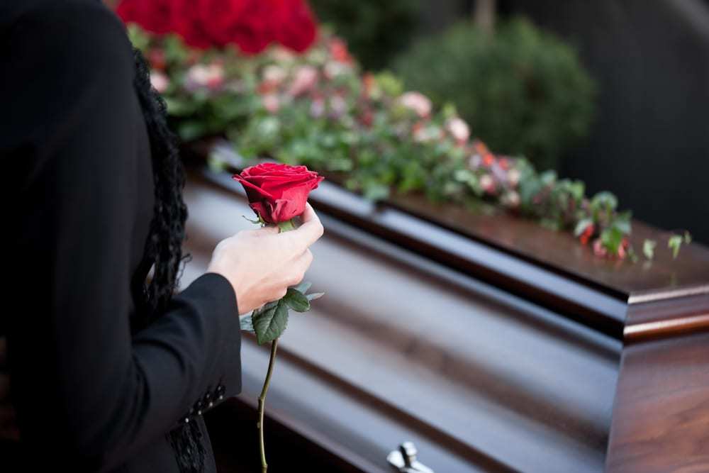 Woman holding a rose at a funeral
