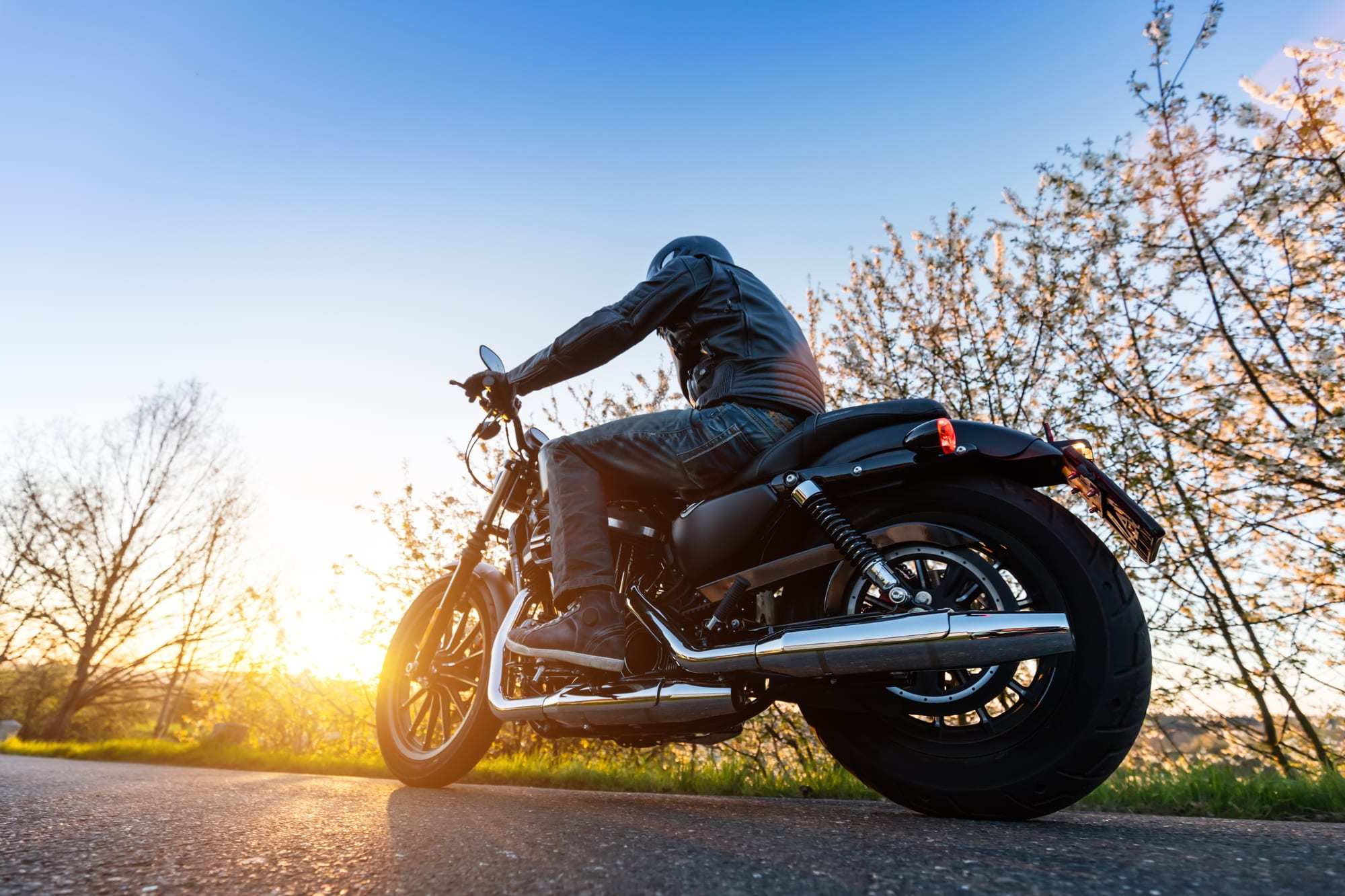 Shot-from-below-of-man-ridiing-chopper-motorcycle-at-sunset