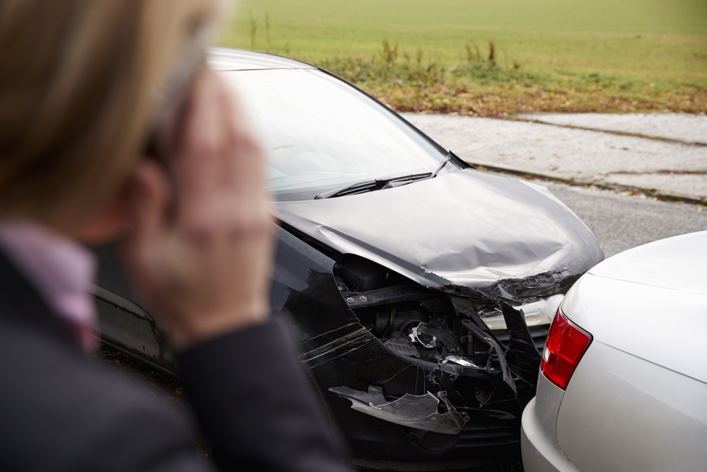 Close-up of woman on phone looking at car accident