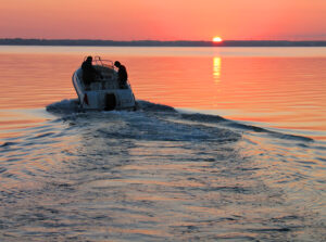 Motorboat in lake at sunset
