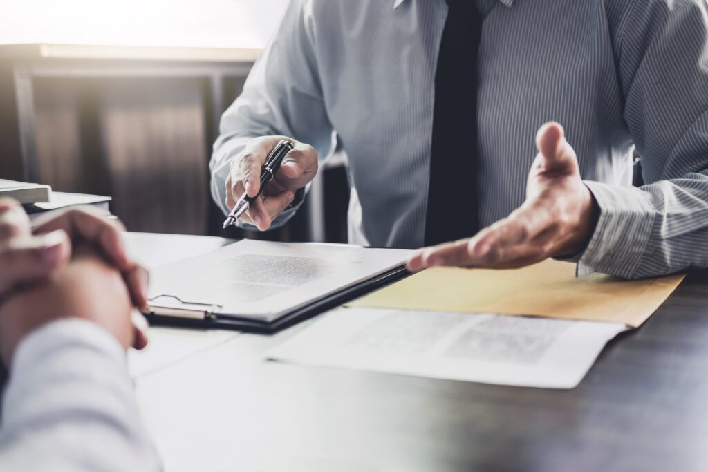 Close-up of lawyer explaining something, using hands, paper on desk