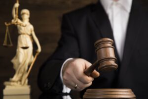 Close-up of judge holding gavel, scales of justice