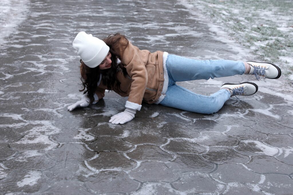 Young woman slipping on icy sidewalk
