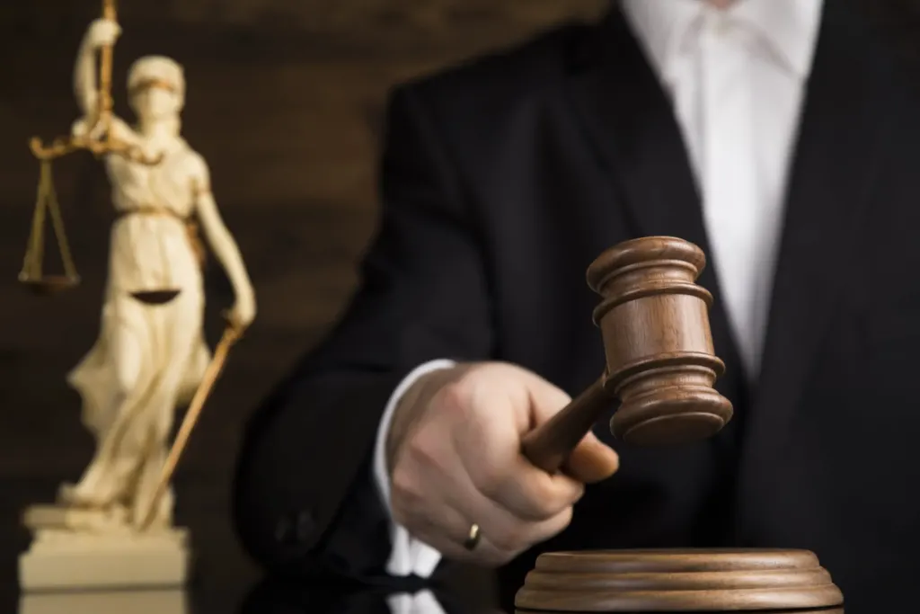 Close-up of judge holding gavel, scales of justice