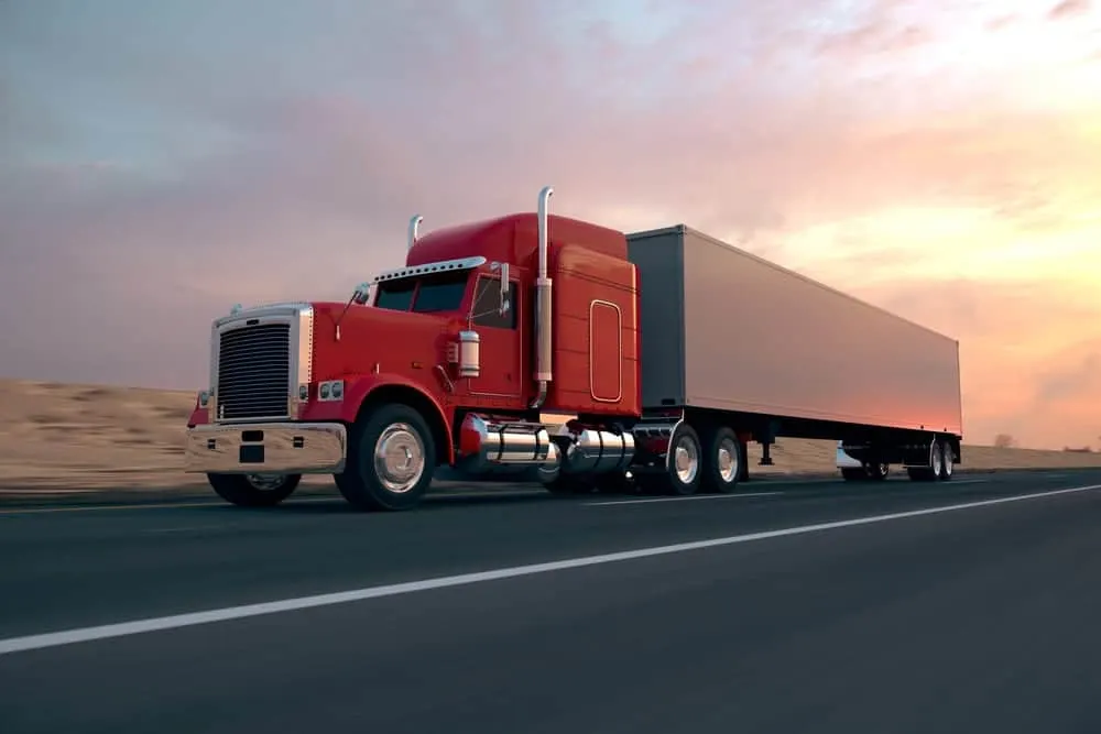 Semi-truck on highway at sunset