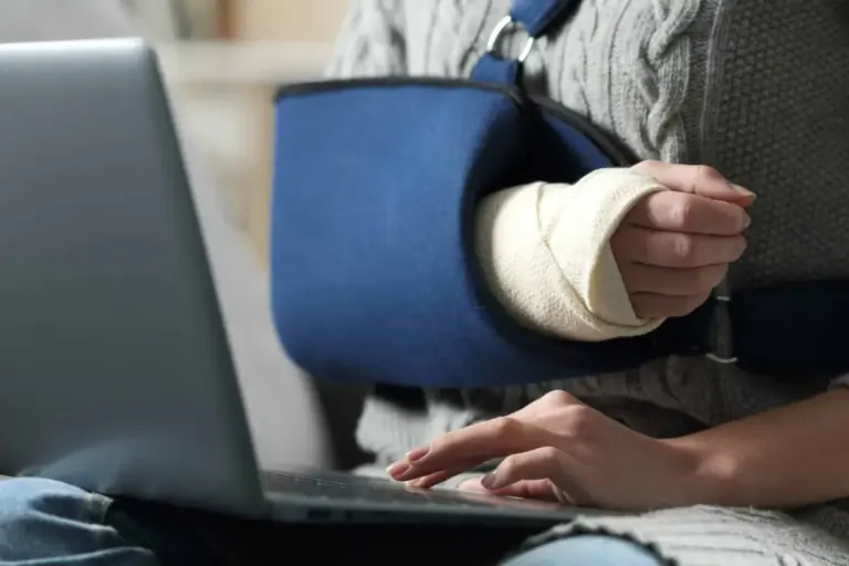 Woman with broken arm using laptop close-up
