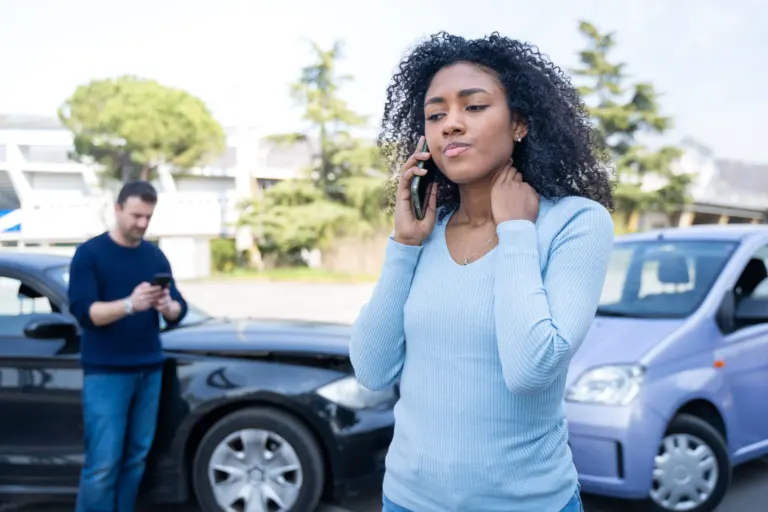 Young woman on phone, car accident in background
