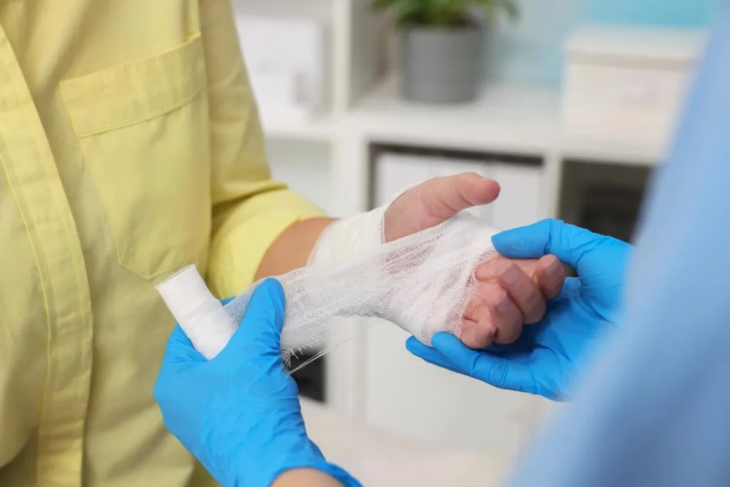 Doctor wrapping arm in gauze