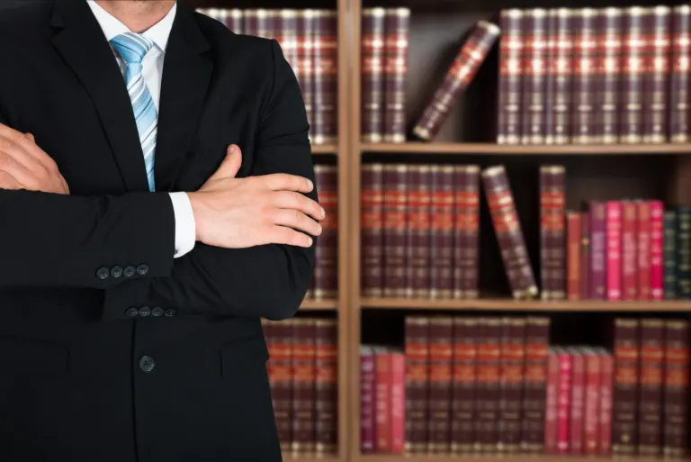 cropped photo of lawyer standing in front of books